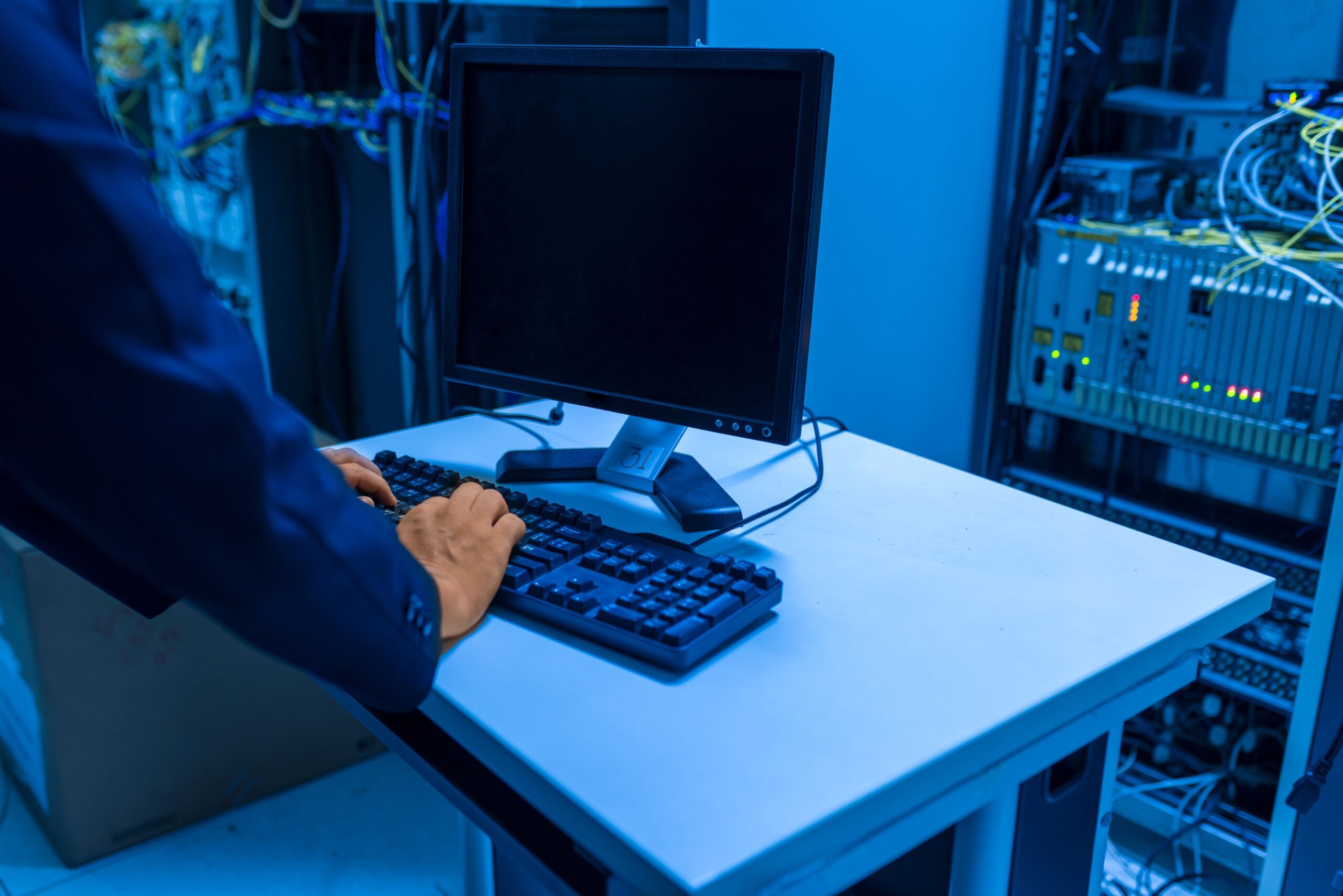 Technicien informatique travaillant sur un poste dans une salle serveurs