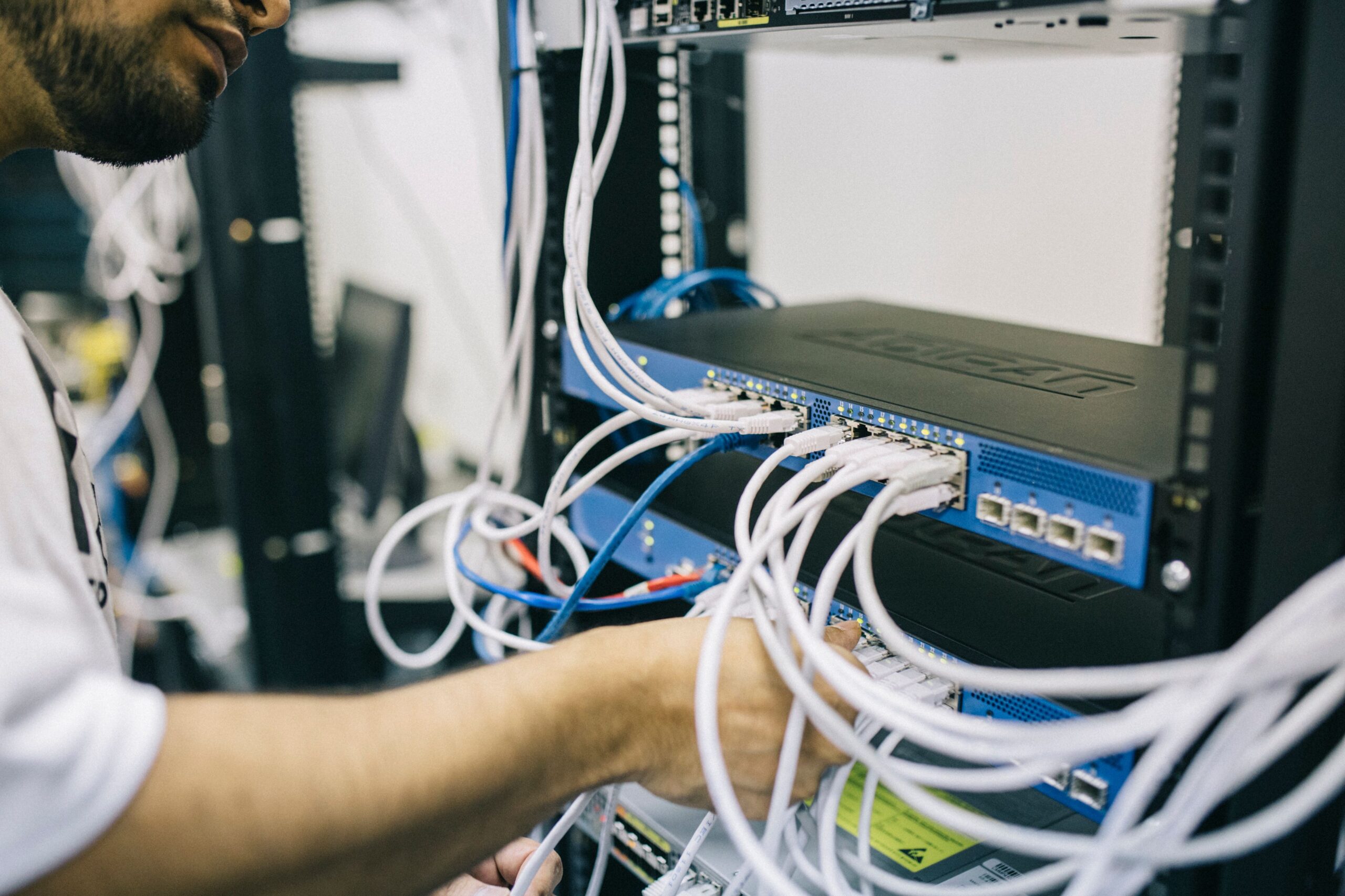 Technicien configurant des câbles réseau Ethernet dans une baie informatique