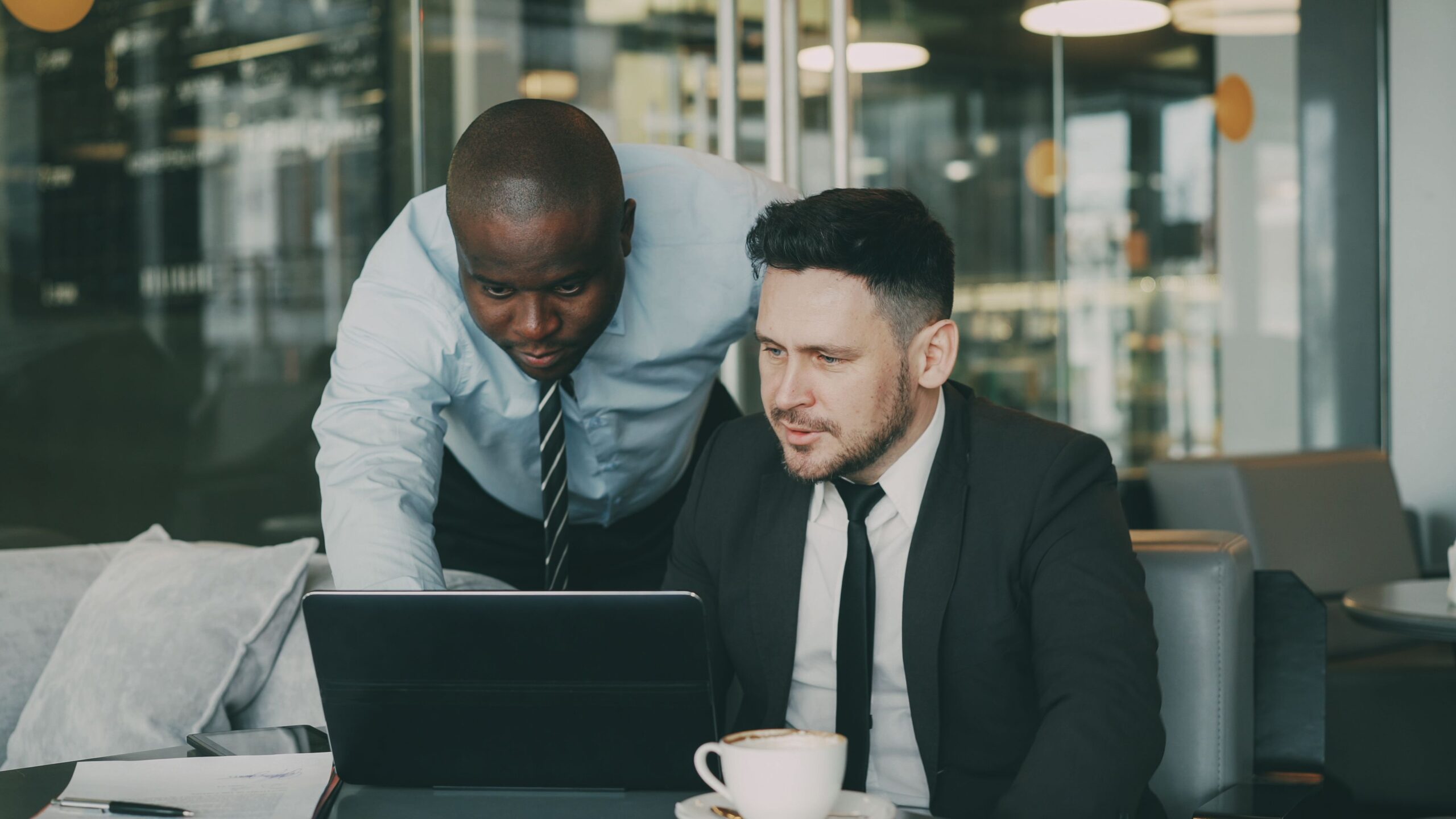 Deux professionnels échangeant devant un ordinateur portable dans un bureau